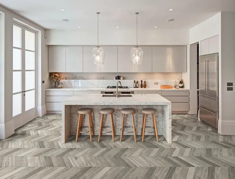 Chevron and herringbone patterns create dynamic, eye-catching movement on kitchen floors, adding elegance and visual flow to any space.